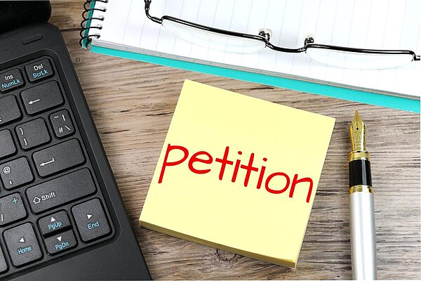 Petition post-it note, pen & keyboard - Petition by Nick Youngs on CC BY-SA 3.0 Alpha Stock Images